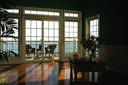 Gridded patio doors that lead out to an upper deck overlooking the ocean.