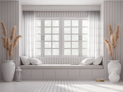 Vintage style window seat 3d render.There are white wood plank wall and floor Decorated with big white jar with dry reed flower. Large windows looking out to see nature.