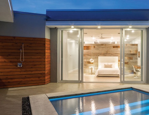 Open sliding glass patio doors leading out to a pool area.