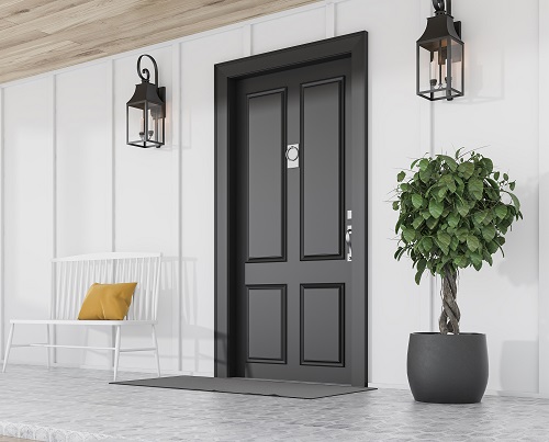 Side view of stylish black front door of modern house with white walls, door mat, potted tree, and beautiful lamps. 