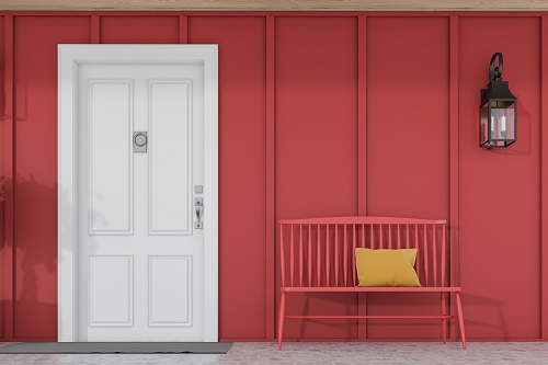 Stylish white front door of modern house with red board and batten walls, a red bench, and lamp. 