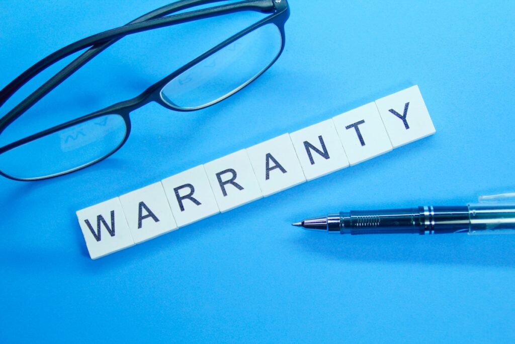 Warranty text with eyeglasses and pen on a blue background