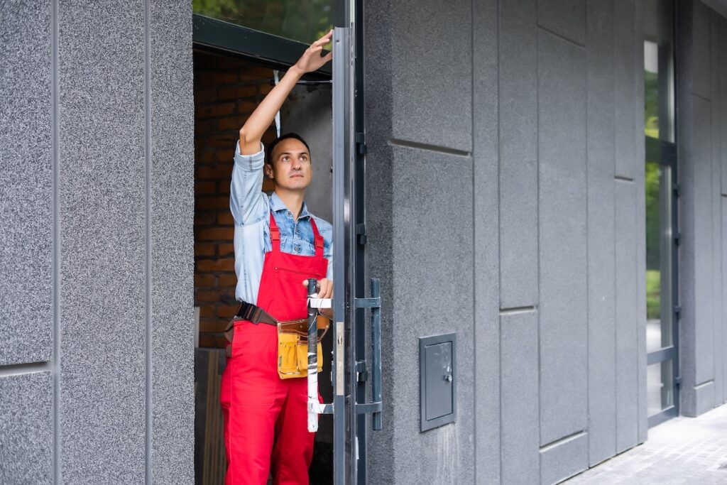 Handyman installing a lock on an entrance door with a screwdriver