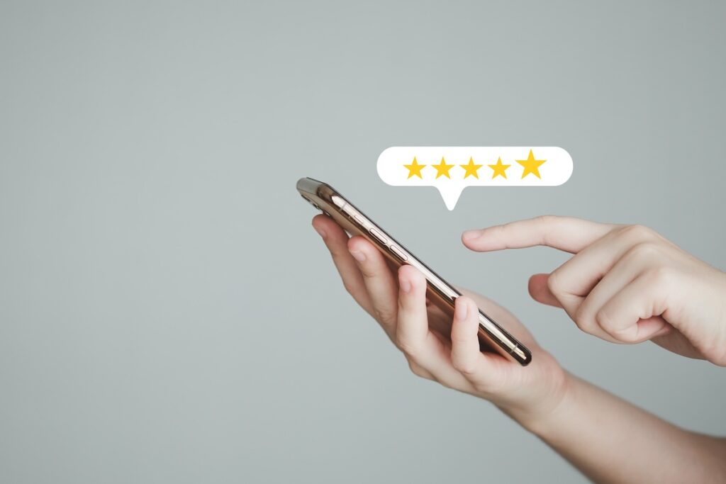 Hand giving a five-star review on a smartphone screen