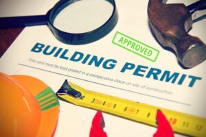 Approved building permit with tools and measuring tape on a work surface