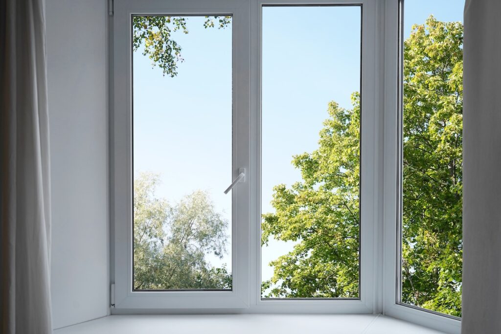 White replacement window with a view of trees outside