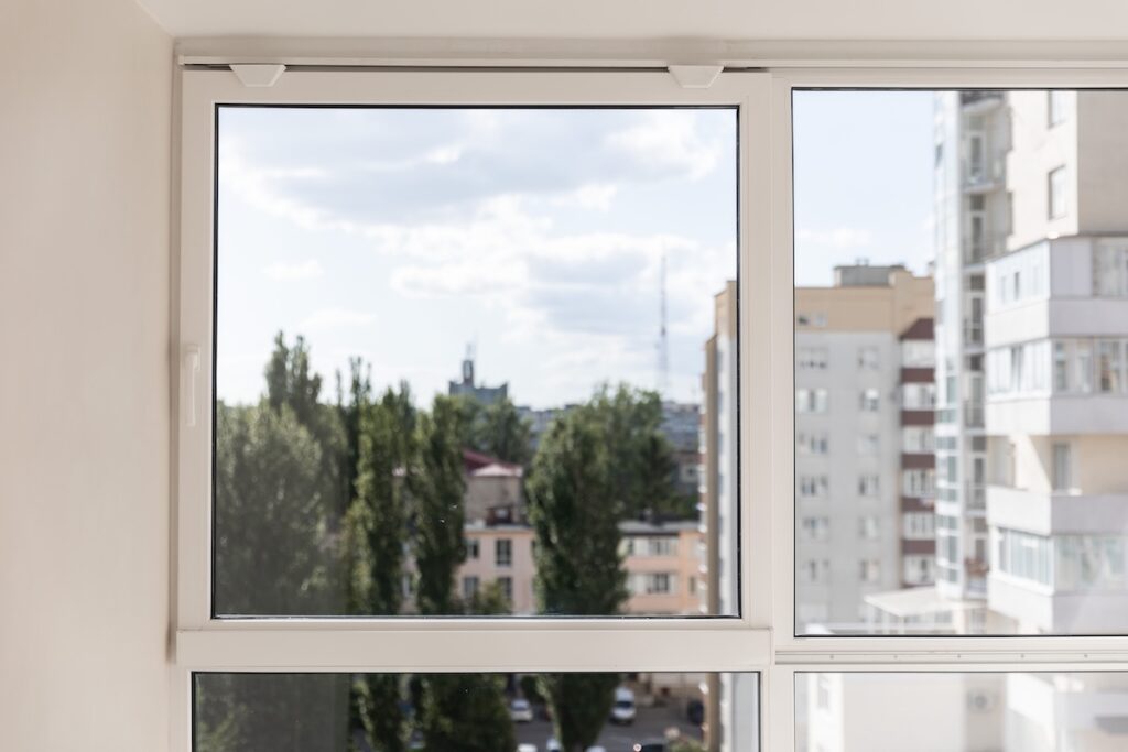 Large white sliding window with an urban view outside