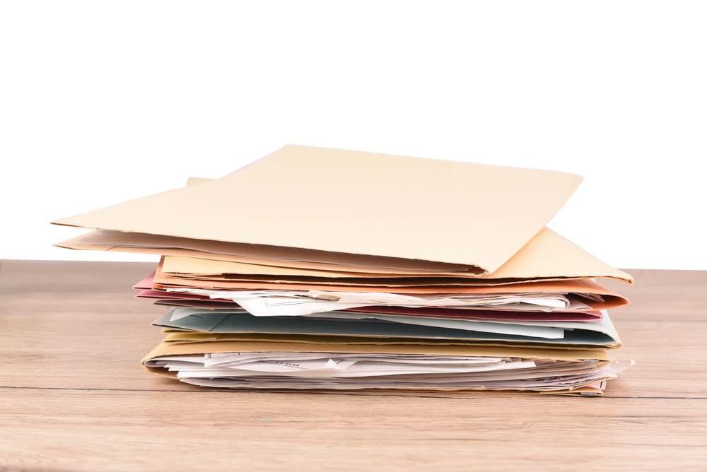 Stack of documents and folders on a wooden table