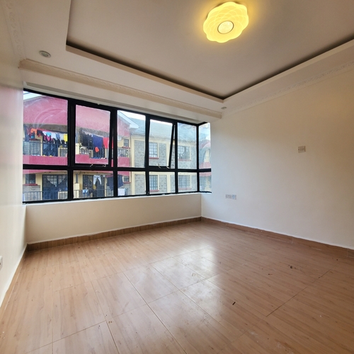Empty room with large black-framed windows bringing in natural light