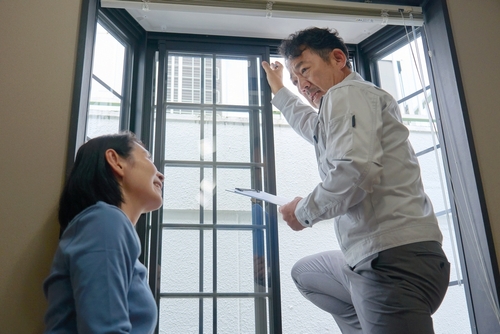 Home window installer explaining frame details to a homeowner during an in-home inspection