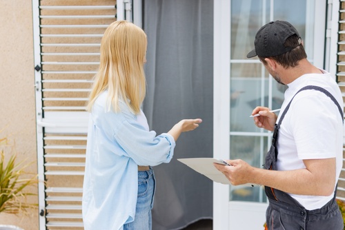 Homeowner reviewing exterior window concerns with installer during an on-site consultation